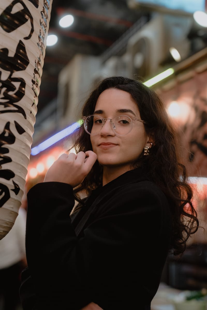 Julia Rocha, fundadora e diretora criativa da Ikigai, em uma viela iluminada no Japão